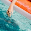 a person in a pool float with their hand in the water